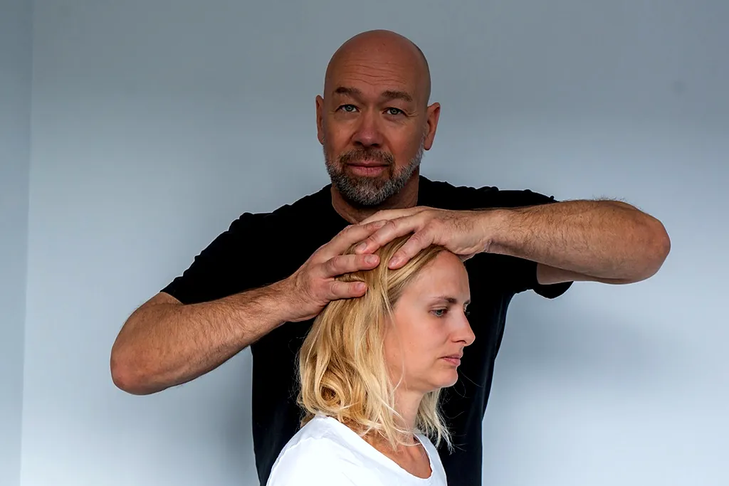Behandlung im Sitzen: beide Hände am Kopf der Patientin, Scalp-Concept®